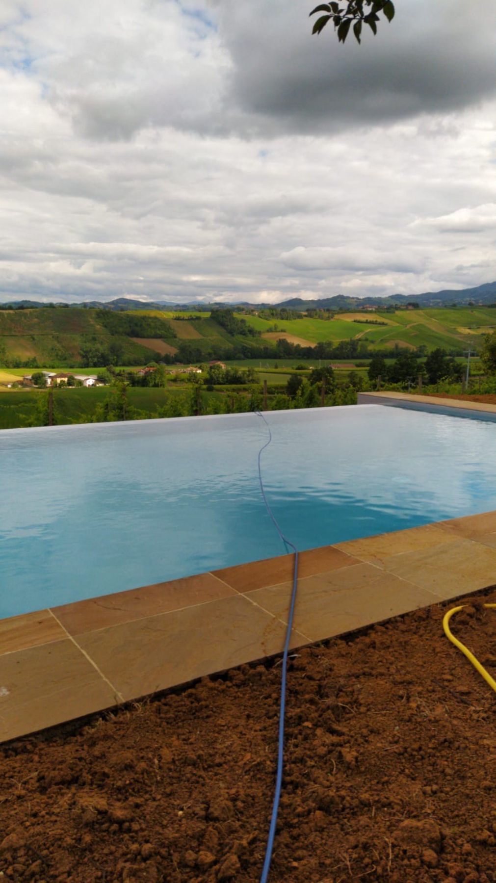 Piscina a sfioro su un lato con telo grigio chiaro