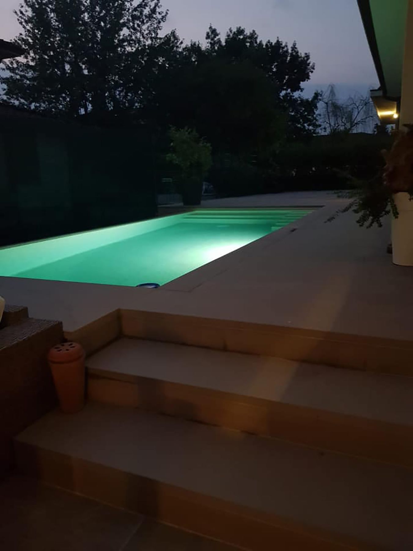 Piscina a sfioro su un lato con tracimazione laterale e telo touch sublime