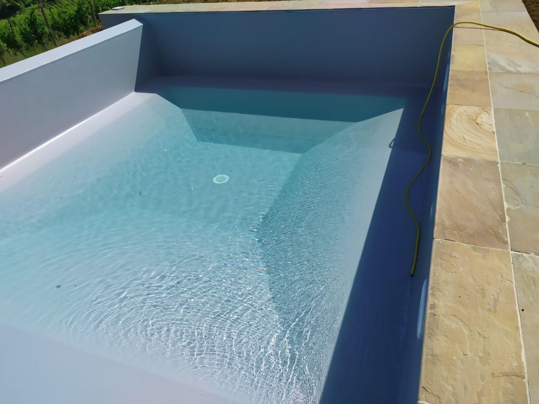 Piscina a sfioro su un lato con telo grigio chiaro