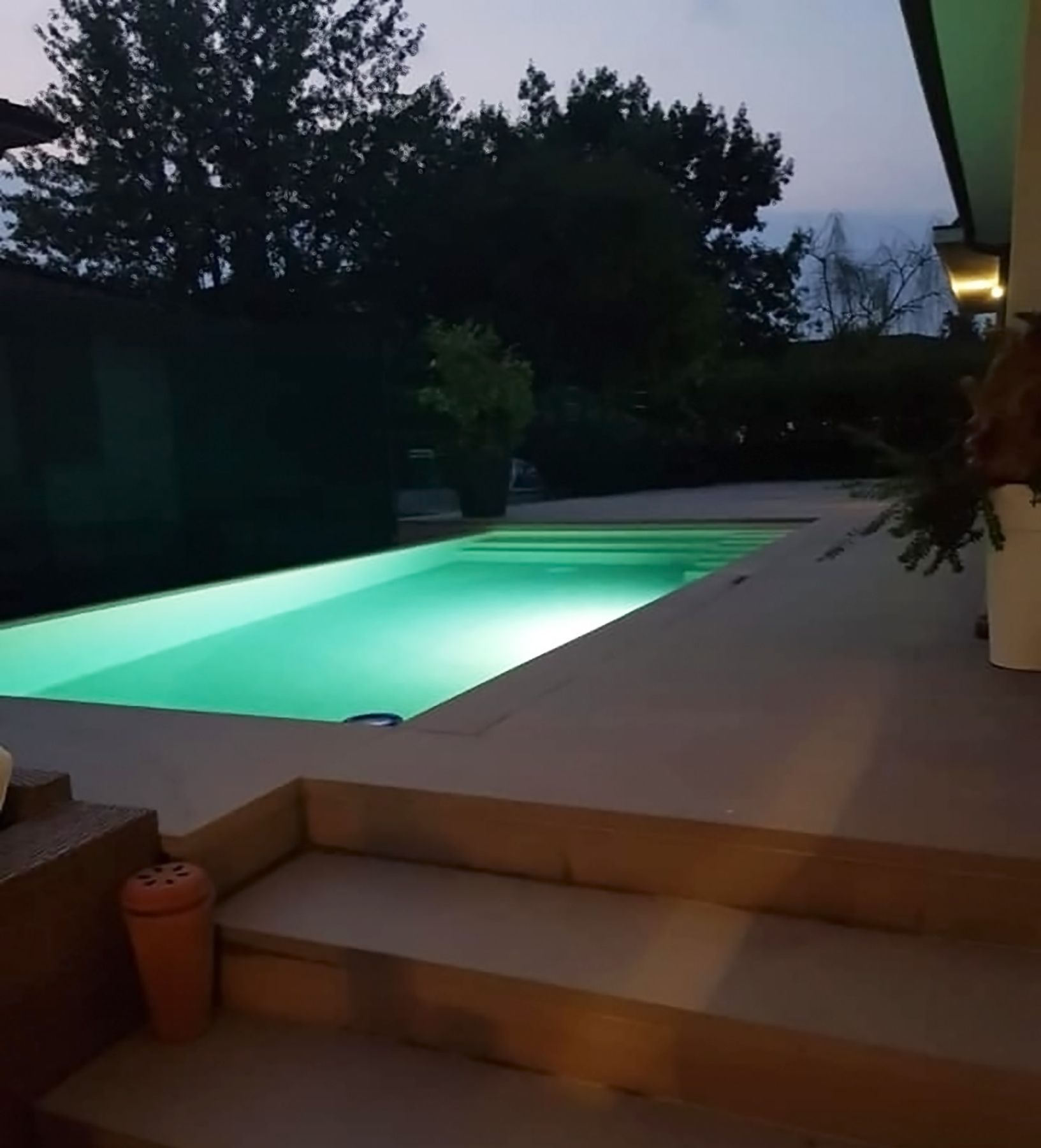 PISCINA A SFIORO SU UN LATO CON TRACIMAZIONE LATERALE Piscina a sfioro
