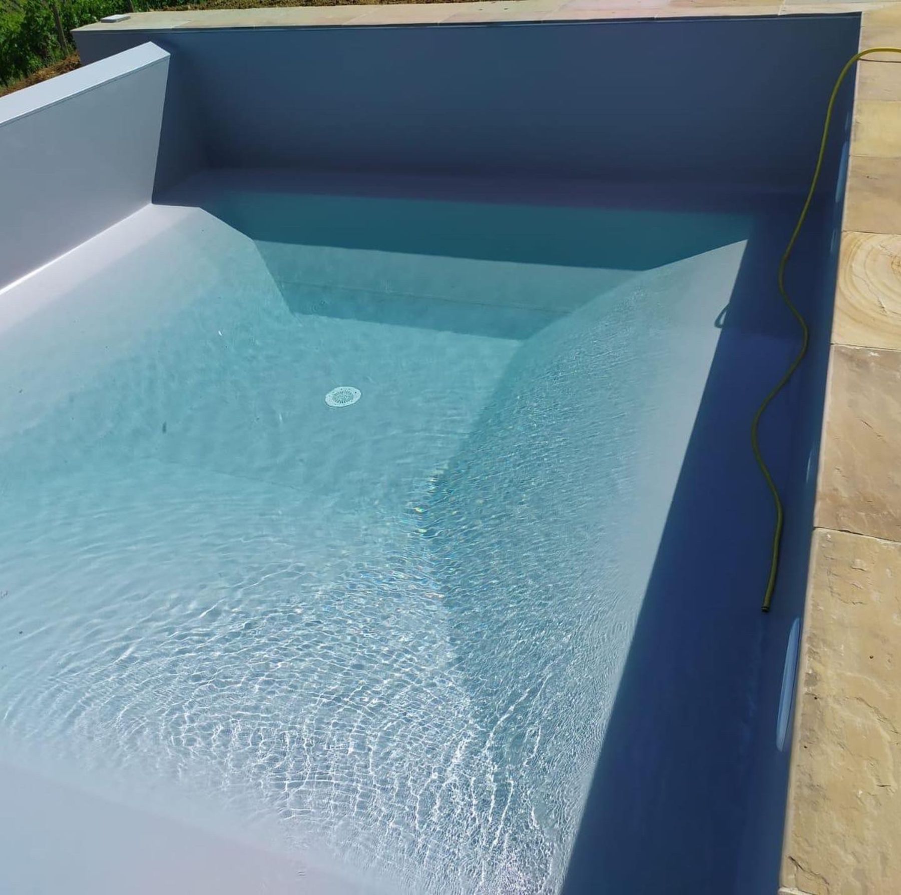 Piscina a sfioro su un lato con telo grigio chiaro