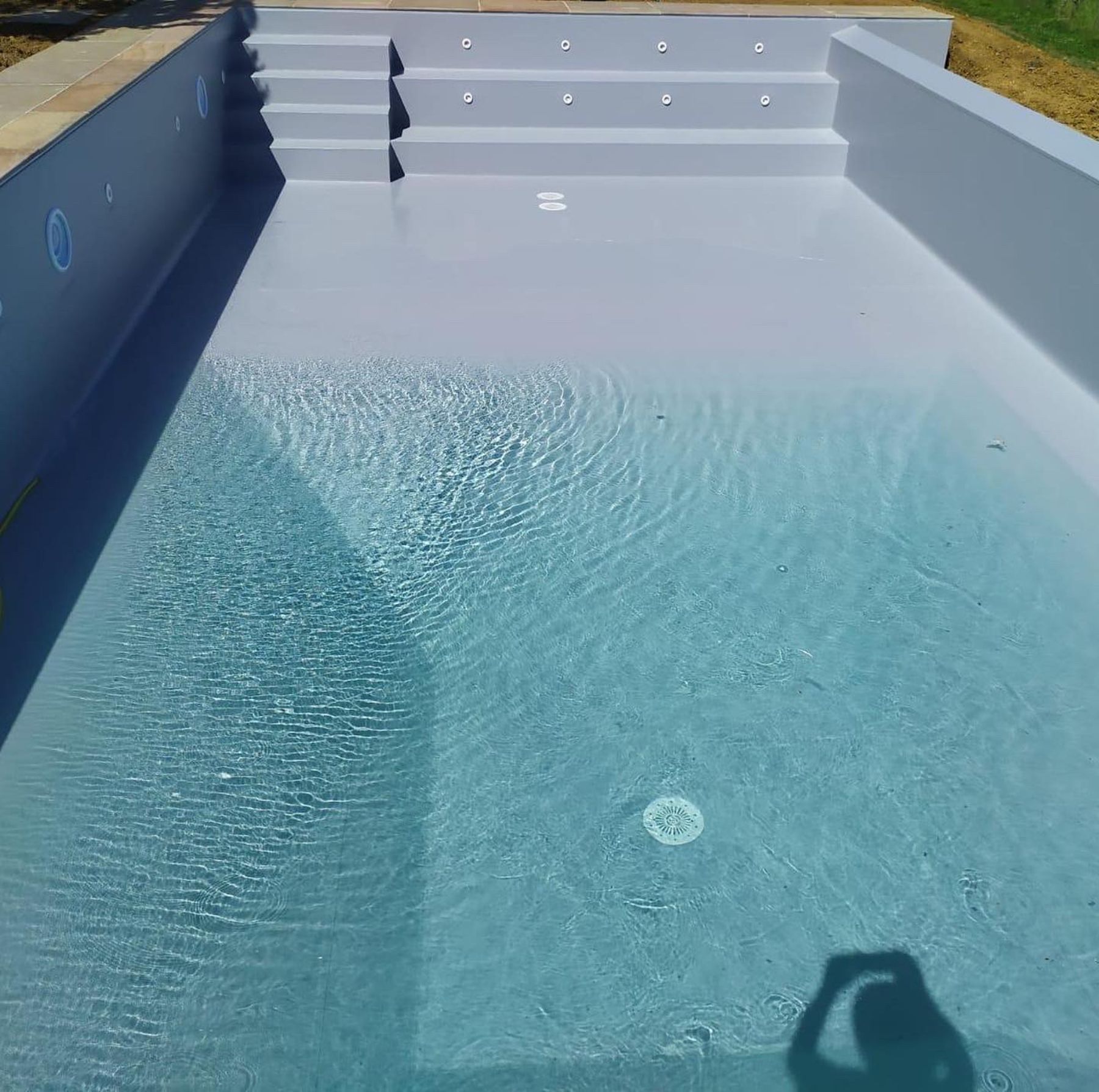 Piscina a sfioro su un lato con telo grigio chiaro