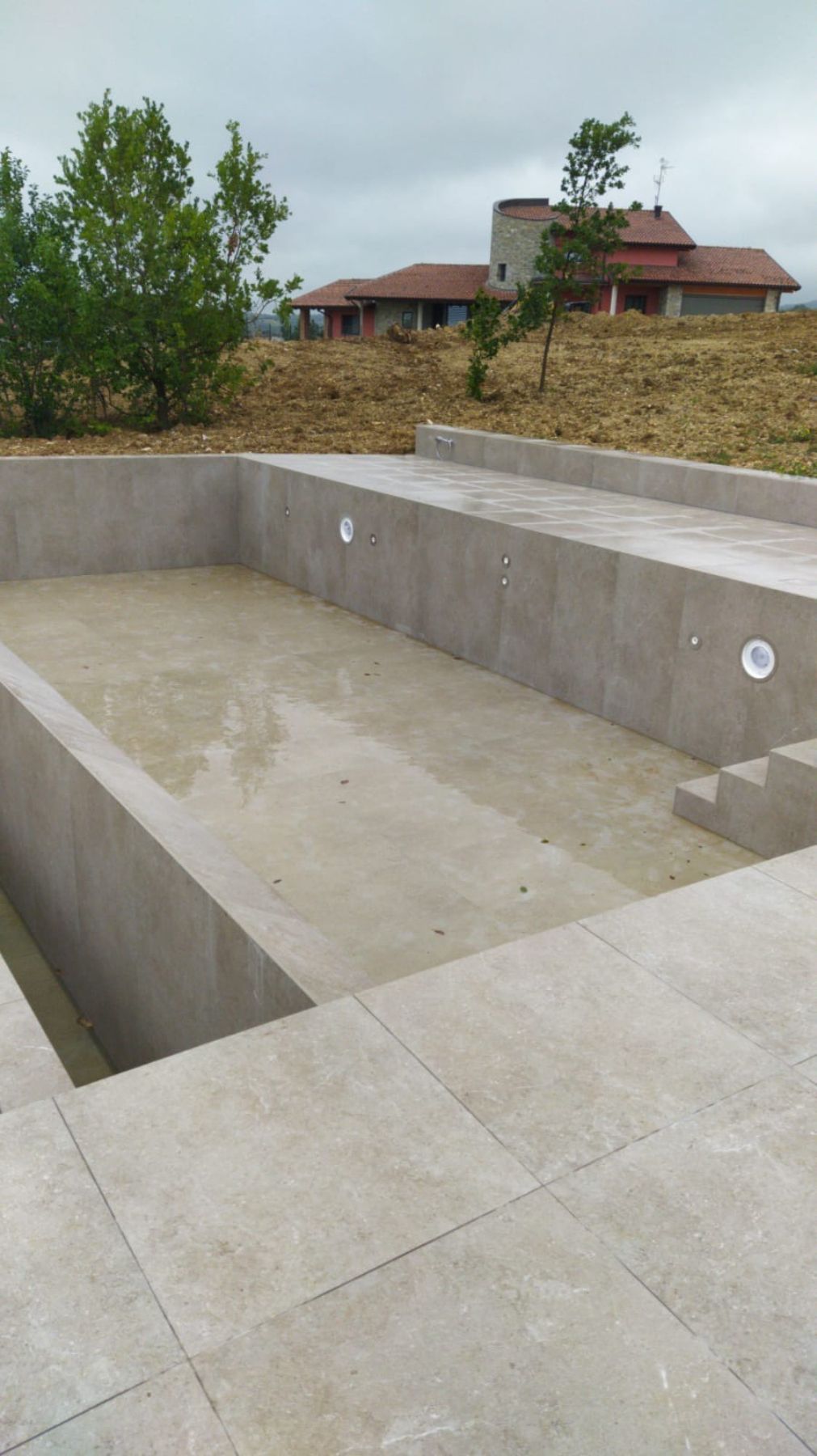 Piscina a sfioro con tracimazione su un lato. Piscina a sfioro con tracimazione su un lato.