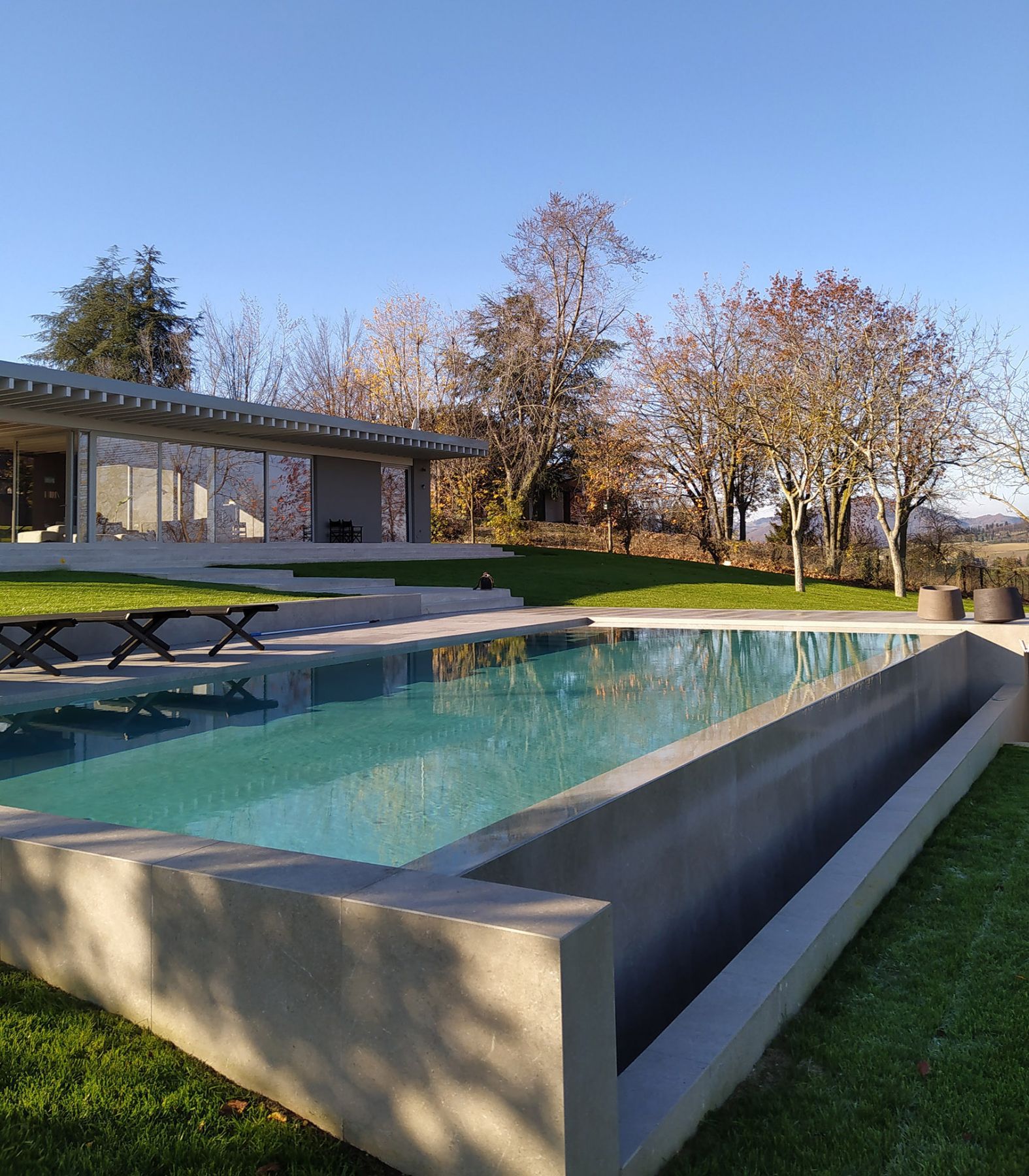 Piscina a sfioro con tracimazione su un lato. Piscina a sfioro con tracimazione su un lato.