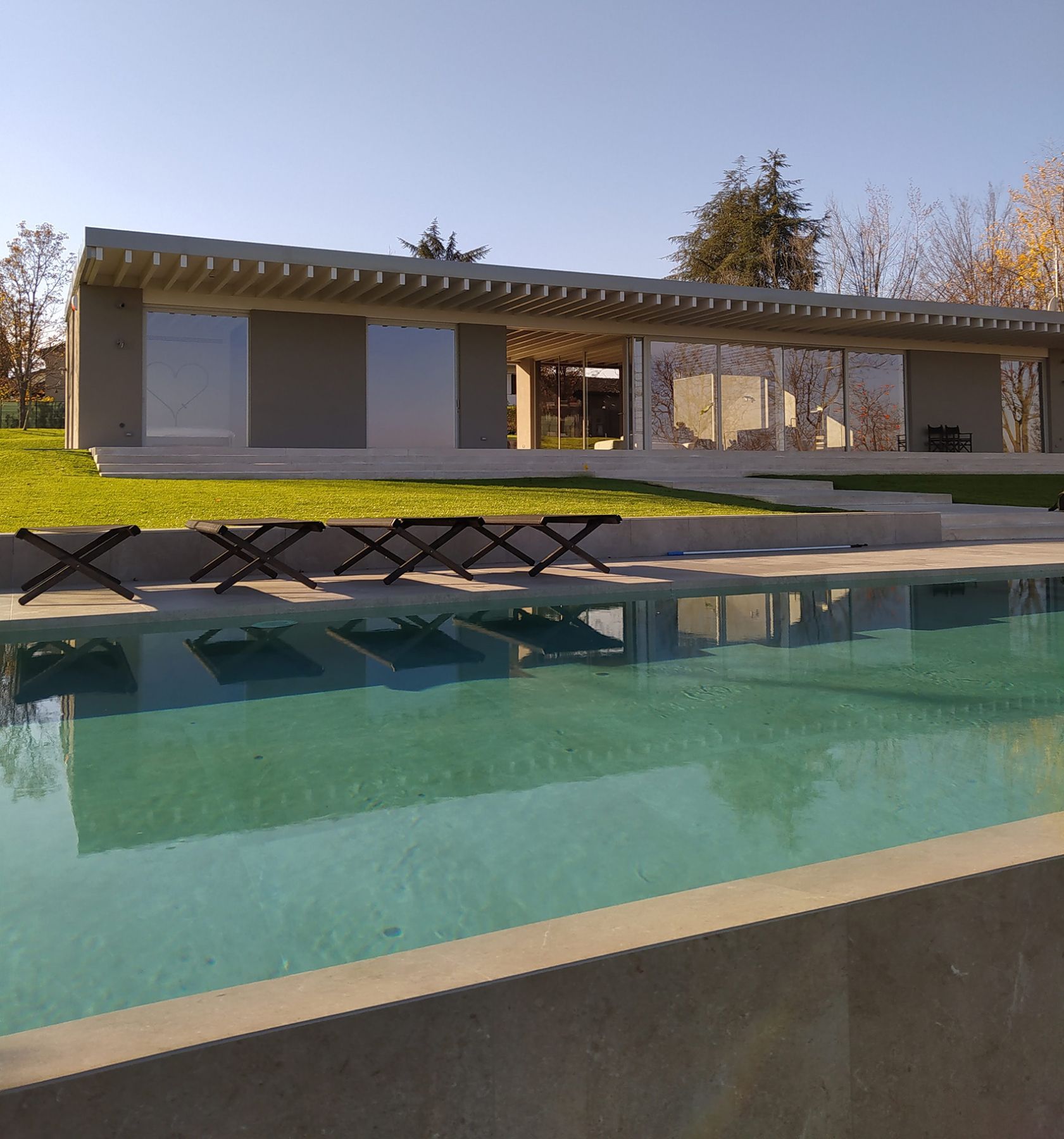Piscina a sfioro con tracimazione su un lato. Piscina a sfioro con tracimazione su un lato.