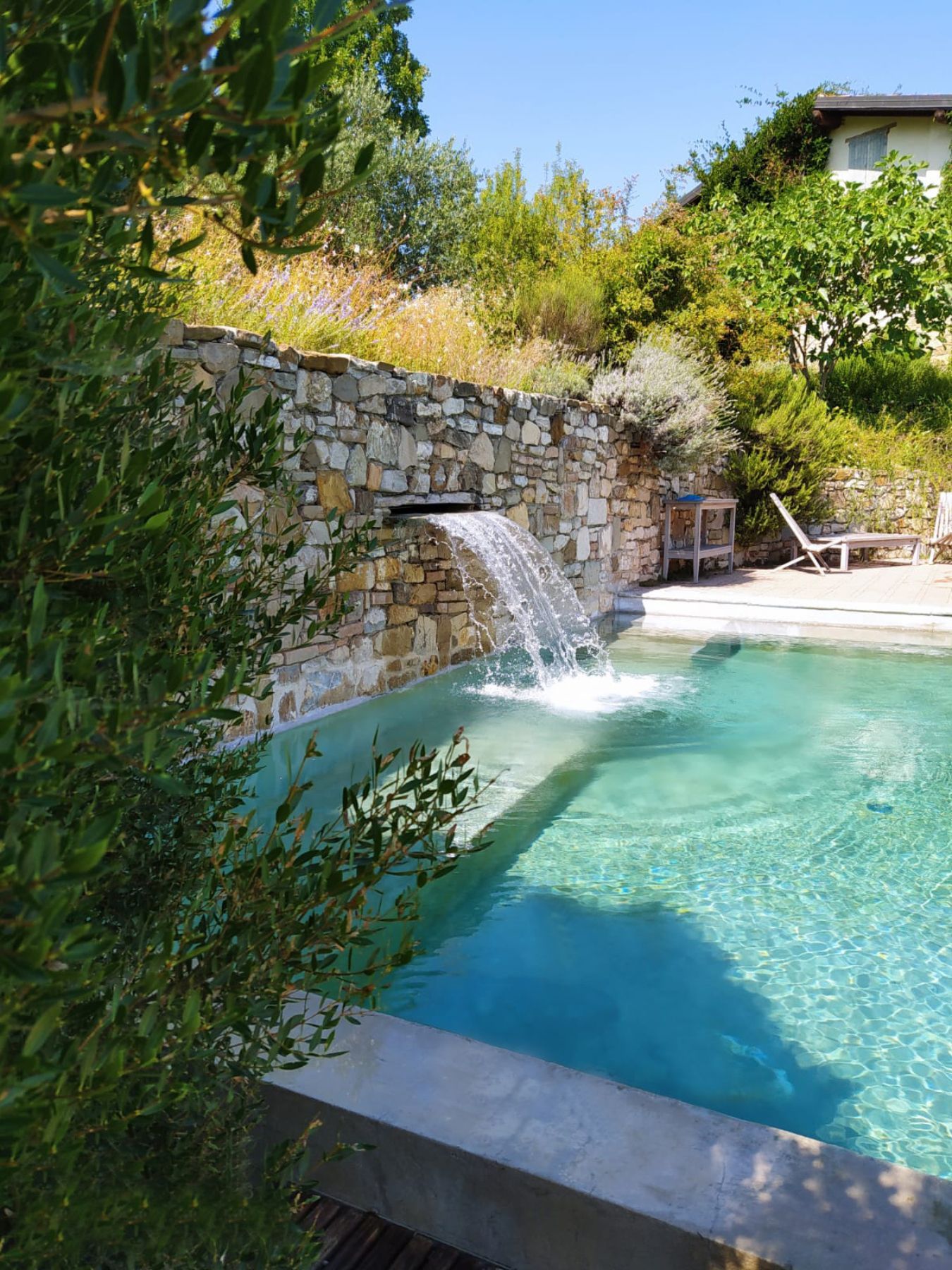 Piscina a sfioro su un lato con cascata e idromassaggio