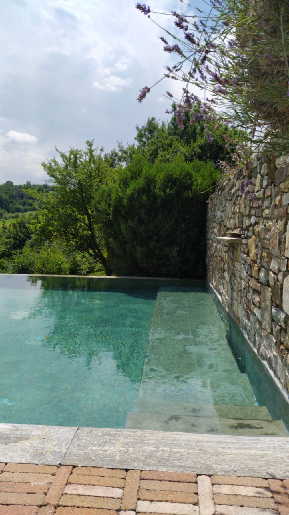 Piscina a sfioro su un lato con cascata e idromassaggio