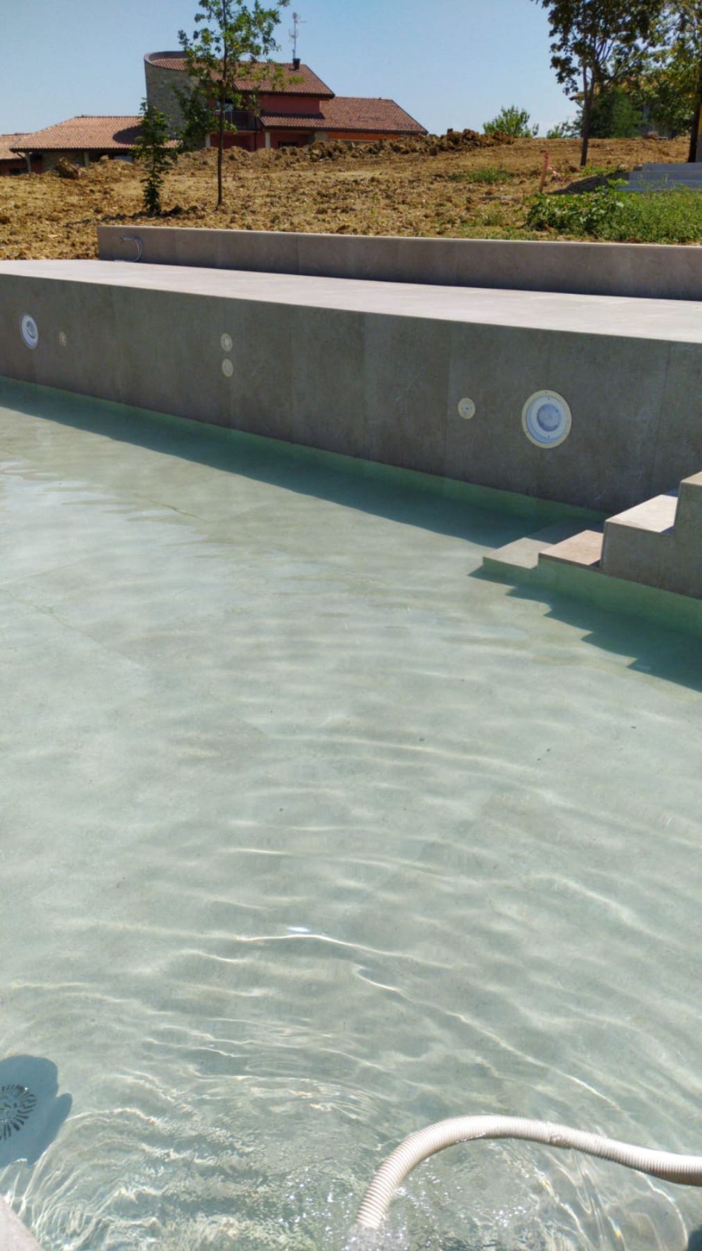 Piscina a sfioro con tracimazione su un lato. Piscina a sfioro con tracimazione su un lato.